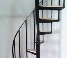 Escaleras marinas curvadas de madera y acero en la habitación de una casa