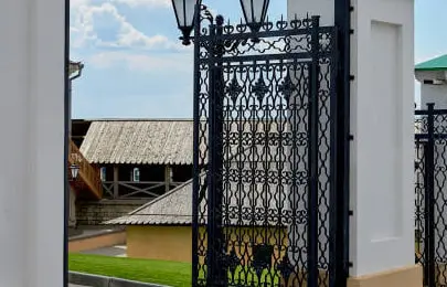 Acercamiento a una reja abatible de color negro en la entrada de una casa