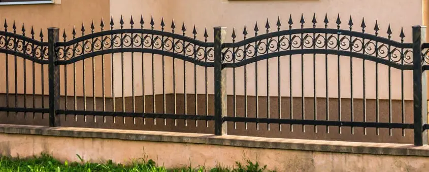 Reja de herrería elaborada con pefiles juntos sobre la barda de una casa