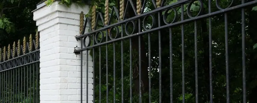 Reja de herrería fija sobre una barda de piedra en una casa