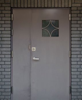 Puerta de herrería para entrada principal con diseño de doble hoja desigual y ventana