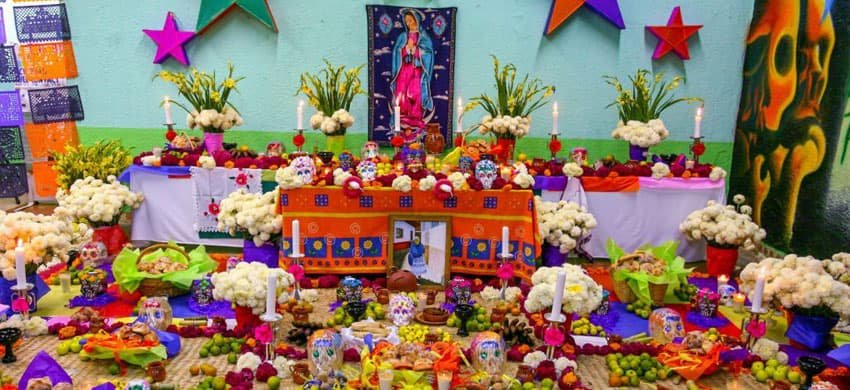 Ofrenda de Día de Muertos con elementos católicos de la conquista y tradiciones de México prehispánicos