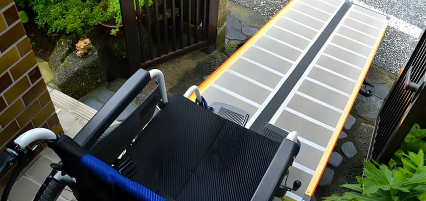 Rampa para discapacitados telescópica puesta sobre una escalera de concreto
